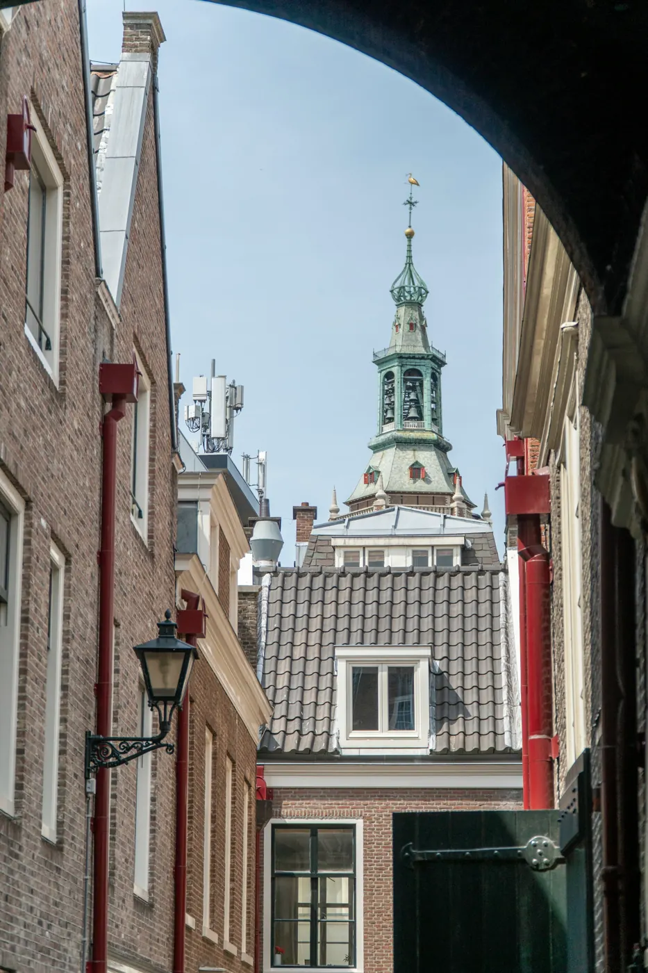 Een smal straatje met zicht op een Haagse kerktoren